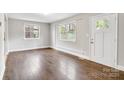 Bright living room featuring updated flooring, a large window, and a white front door at 2815 Grimes St, Charlotte, NC 28206
