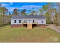Charming single-story home featuring a freshly stained front porch and a well-maintained yard in a tranquil setting at 2895 Sweeping Pine Ln, Denver, NC 28037