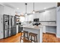 Stylish kitchen with white cabinets, stainless steel appliances, a granite island with bar seating, and pendant lighting at 2895 Sweeping Pine Ln, Denver, NC 28037
