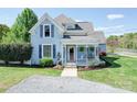 Charming blue two-story home with a welcoming front porch, gravel driveway, and well-manicured lawn at 3241 Long Shoals Rd, Lincolnton, NC 28092