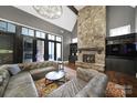 Open living room with stone fireplace, vaulted ceilings, and leather couch showcases a comfortable gathering space at 4071 Poplar Ridge Dr, Fort Mill, SC 29715