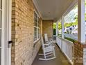 Cozy front porch with rocking chairs and white railing provides a relaxing outdoor space to enjoy the neighborhood at 4407 Coventry Row Ct, Charlotte, NC 28270