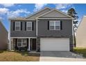Charming two-story home with gray siding, stone accents, and a two-car garage for convenient parking at 4538 Opus Ln, Charlotte, NC 28214