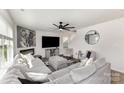 Spacious living room featuring a comfortable gray sectional, a fireplace, and a ceiling fan at 4538 Opus Ln, Charlotte, NC 28214