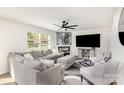 Spacious living room featuring a comfortable gray sectional, a fireplace, and a ceiling fan at 4538 Opus Ln, Charlotte, NC 28214