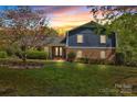 Charming two-story home with a brick facade and a well-manicured lawn during a vibrant sunset at 4937 Broken Saddle Ln, Charlotte, NC 28226