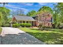 Traditional two-story home with a brick exterior, well-kept lawn and a long driveway at 4937 Broken Saddle Ln, Charlotte, NC 28226
