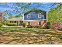 Traditional two-story home with a brick exterior, well-kept lawn and mature trees with shadows at 4937 Broken Saddle Ln, Charlotte, NC 28226