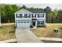 Beautiful home with gray siding, a two-car garage, and a spacious driveway in a landscaped yard at 5861 Camp Sw Ct, Concord, NC 28025