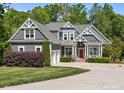Charming two-story home with gray siding, white trim, a red front door, and a well-manicured front yard at 6743 Fox Ridge Cir, Davidson, NC 28036