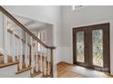 Elegant foyer features a wooden staircase, hardwood floors, and a decorative glass front door at 9008 Skipaway Dr, Waxhaw, NC 28173
