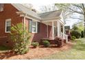 Charming brick home featuring a covered porch and neat landscaping on a sunny day at 920 N Sixth St, Albemarle, NC 28001