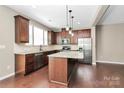Modern eat-in kitchen featuring a center island, stainless steel appliances, and hardwood flooring at 9551 Glenburn Ln, Charlotte, NC 28278