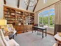 A charming home library showcasing custom shelving, a rolling ladder, large windows and ample natural light at 1012 Shippon Ln, Waxhaw, NC 28173
