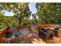 Spacious wooden deck with outdoor seating, overlooking the serene lake and lush greenery at 119 Harbor Ln, Mount Gilead, NC 27306
