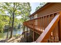 Waterfront home featuring a wooden deck with railings, offering stunning lake views at 119 Harbor Ln, Mount Gilead, NC 27306