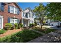 Beautifully landscaped front yard with lush green grass and a charming townhouse with blue shutters and a well-manicured lawn at 121 Talbert Town Loop, Mooresville, NC 28117