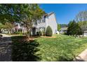 Scenic view of townhouses with lush green lawns, mature trees, and well-maintained landscaping on a bright, sunny day at 121 Talbert Town Loop, Mooresville, NC 28117
