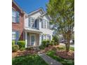 Attractive townhouse featuring a mix of brick and siding, accented by neat landscaping and a welcoming front entrance at 121 Talbert Town Loop, Mooresville, NC 28117