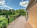 Expansive wooden deck overlooking a serene pond surrounded by lush greenery and mature trees at 1231 Restoration Dr, Marvin, NC 28173