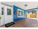 Inviting front porch featuring blue siding, rustic shutters, a wooden floor, and a 'hello' welcome mat at 166 Franklin Nw Ave, Concord, NC 28025