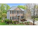 Charming brick-and-siding home with inviting front entrance, lush greenery, and attached two-car garage at 1809 Robbins Meadows Dr, Waxhaw, NC 28173