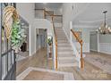 Spacious foyer with a staircase featuring wood handrails, light walls, and wood floors at 1809 Robbins Meadows Dr, Waxhaw, NC 28173