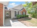 A charming home exterior with a brick accent wall, black shutters, and trimmed landscaping at 219 Edinburgh Ct, Mount Holly, NC 28120