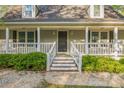 Inviting front porch with white railings, fresh landscaping, and decorative lighting at 2371 Lazy Oak Dr, Lancaster, SC 29720