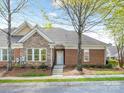 Attractive home exterior featuring a brick and stone facade, complemented by mature trees at 2874 Bellasera Way, Matthews, NC 28105