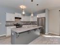 Bright kitchen with gray island, pendant lighting, stainless steel appliances, and ample cabinet space at 317 Contentment Dr, Locust, NC 28097