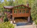 A garage sits under a beautiful home that has an elevated deck and gorgeous landscaping at 3605 Ridgetop Rd, Sherrills Ford, NC 28673