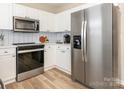 Bright kitchen featuring white cabinets, stainless steel appliances, and modern backsplash at 4628 Arthur Way, Rock Hill, SC 29732