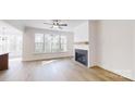 Inviting living room with hardwood floors, a cozy fireplace, and large windows overlooking the backyard at 472 Bellingshire Dr, Mt Ulla, NC 28125