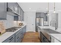 Bright kitchen showcasing gray cabinets, white countertops, stainless steel appliances, and wood floors at 7105 Short Stirrup Ln, Mint Hill, NC 28227