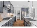 Contemporary kitchen with gray cabinets, a pantry, stainless steel appliances, and elegant countertops at 7105 Short Stirrup Ln, Mint Hill, NC 28227