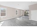 Bright living room featuring gray wood-look floors and several windows for natural light and an open floor plan at 8722 Moody Rd, Charlotte, NC 28215