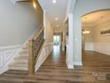 Inviting foyer with hardwood floors, staircase, and elegant archway to the dining room at 10024 Fox Trotter Ln, Midland, NC 28107