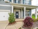 Charming front porch with a 'Welcome' wreath, cozy seating, and manicured landscaping at 10024 Fox Trotter Ln, Midland, NC 28107