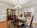 Formal dining area featuring a wooden table set, chairs, hardwood floors, and display cabinet at 10626 Newberry Park Ln, Charlotte, NC 28277