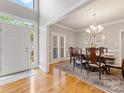Inviting dining room with hardwood floors, elegant chandelier, and a doorway leading to the outside at 10626 Newberry Park Ln, Charlotte, NC 28277
