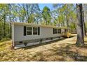 Charming single-story home featuring gray siding, black shutters and a small wooden porch at 110 Matthew Dr, Kings Mountain, NC 28086