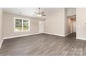 Bright living room with vaulted ceilings, ceiling fan, gray wood-look flooring, and natural light from the window at 115 Frances St, Salisbury, NC 28147
