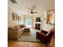 Comfortable living room with a fireplace, ceiling fan, and sliding glass doors to the patio at 14022 Drake Watch Ln, Charlotte, NC 28262