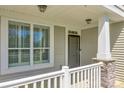Close-up of the front porch with stone and wooden column accents and a storm door at 14905 Skyscape Dr, Huntersville, NC 28078