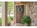 Stylish front door featuring a decorative wreath, potted plant, and stone accents creating an inviting entryway at 2001 Cramer Place Ct, Cramerton, NC 28032