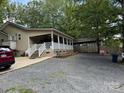 Exterior shot showing the side of a home, gravel driveway, and surrounding trees at 207 Deer Park Rd, Mount Gilead, NC 27306