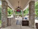 Outdoor kitchen and entertainment area with a built-in grill, seating, and a TV for ultimate outdoor enjoyment at 2553 Fallbrook Nw Pl, Concord, NC 28027