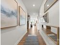 Bright hallway showcasing modern art, mirrors, and hardwood flooring at 2573 Blue Sky Meadows Dr, Monroe, NC 28110