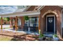 Charming front porch featuring rocking chairs, hanging plants, and a welcoming entrance with arched stonework at 2701 N Main Ave, Newton, NC 28658